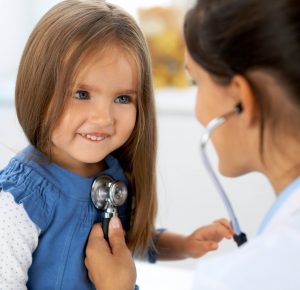 A child being checked up by a nurse
